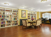 Thumbnail 5 of 29 - A room with a table and chairs in front of a bookshelf.