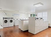 Thumbnail 12 of 29 - A laundromat with washers and dryers.