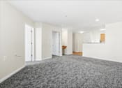Thumbnail 22 of 29 - A large empty room with carpeted floor and white walls.