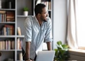 Thumbnail 1 of 27 - a man standing in front of a laptop computer