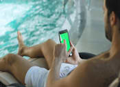 Thumbnail 2 of 27 - a man sitting in a chair holding a cell phone