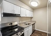 Thumbnail 7 of 22 - A kitchen with white cabinets and a black stove top oven.