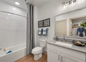 Thumbnail 9 of 44 - A white bathroom with a toilet, sink, and bathtub.