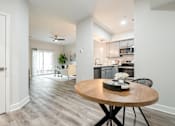 Thumbnail 7 of 31 - A modern kitchen with a round wooden table and chairs.
