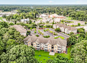 Thumbnail 27 of 31 - A bird's eye view of a large apartment complex surrounded by trees.