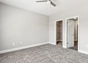 Thumbnail 6 of 18 - A room with a ceiling fan and two open doors.
