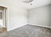 Thumbnail 9 of 18 - A room with a ceiling fan and a carpeted floor.