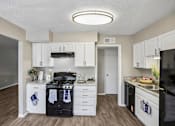 Thumbnail 21 of 37 - A kitchen with white cabinets and a black stove top oven.