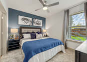 Thumbnail 6 of 44 - A bedroom with a bed, nightstand, and a ceiling fan.