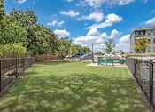 Thumbnail 37 of 44 - A green lawn with a fence and a building in the background.