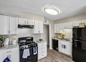 Thumbnail 15 of 37 - A kitchen with black appliances and white cabinets.