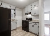 Thumbnail 17 of 29 - 1295 west kitchen with white cabinets and black appliances