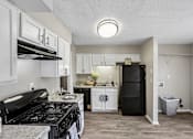 Thumbnail 1 of 37 - A kitchen with black stove top and white cabinets.