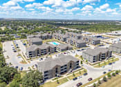 Thumbnail 44 of 44 - A large apartment complex with a swimming pool in the middle.