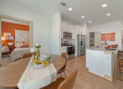 Thumbnail 12 of 44 - A modern kitchen with a dining table set for two.