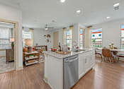Thumbnail 11 of 44 - A modern kitchen with a white island and wooden floors.