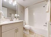 Thumbnail 15 of 17 - A white bathroom with a toilet, sink, and bathtub.