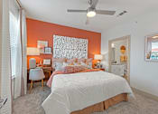 Thumbnail 14 of 44 - A bedroom with a large bed and a ceiling fan.