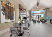 Thumbnail 23 of 44 - A modern dining room with a large abstract painting on the wall and a view of the outdoors through the windows.
