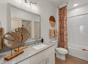 Thumbnail 39 of 44 - A bathroom with a white toilet, a wooden sculpture, and a shower curtain.