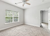 Thumbnail 8 of 18 - A room with a ceiling fan and a window with blinds.