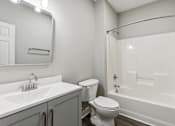 Thumbnail 18 of 18 - A white bathroom with a toilet, sink, and bathtub.
