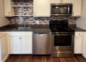Thumbnail 6 of 8 - Kitchen with cabinets at Summit Terrace at Woodland Apartments, Cape Elizabeth, ME, 04107