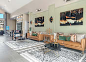 Thumbnail 20 of 44 - A living room with a couch, coffee table, and two paintings on the wall.