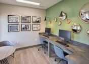 Thumbnail 11 of 14 - a computer desk with two monitors in a room with pictures on the wall