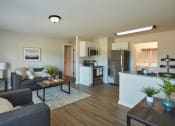 Thumbnail 1 of 14 - a living room and kitchen with a couch and a table