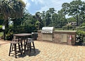 Thumbnail 4 of 16 - A patio with a table and chairs and a grill.