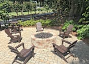 Thumbnail 5 of 16 - A fire pit surrounded by chairs in a backyard.