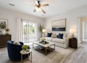 Thumbnail 10 of 31 - A living room with a blue armchair, a white couch, and a coffee table.