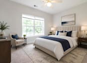 Thumbnail 13 of 31 - A bedroom with a large bed and a ceiling fan.