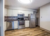 Thumbnail 2 of 15 - Kitchen with stainless steel appliances and wooden floors at Summit Terrace, South Portland, ME