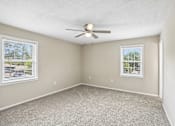 Thumbnail 4 of 37 - A room with a ceiling fan and two windows.