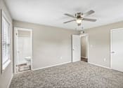 Thumbnail 14 of 37 - A room with a ceiling fan and carpeted floor.