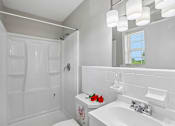 Thumbnail 19 of 37 - A white bathroom with a toilet, sink, and shower.