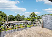 Thumbnail 33 of 37 - A house with a driveway and a fence.