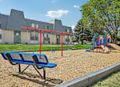 Thumbnail 19 of 22 - A playground with a blue bench and a slide.