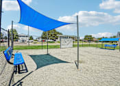 Thumbnail 21 of 22 - A blue shade structure is in a sandy area with benches.