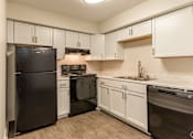 Thumbnail 10 of 24 - a kitchen with white cabinets and black appliances