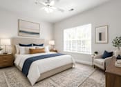 Thumbnail 14 of 31 - A bedroom with a large bed and a ceiling fan.