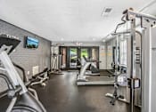 Thumbnail 35 of 37 - A gym with a variety of equipment including treadmills, weights, and exercise machines.