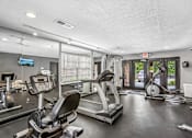 Thumbnail 34 of 37 - A gym with treadmills, elliptical machines, and other exercise equipment.