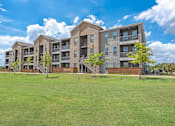 Thumbnail 42 of 44 - A large apartment complex with multiple buildings and green lawns in front.