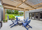 Thumbnail 25 of 37 - A patio with blue chairs and a wooden roof.