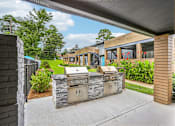 Thumbnail 28 of 37 - A modern outdoor kitchen with a grill and sink.
