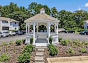 Thumbnail 22 of 22 - A gazebo is surrounded by a flowerbed and steps leading up to it.