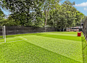 Thumbnail 37 of 37 - A soccer field with a green surface and a red bin.